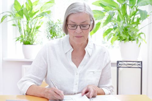 Foto: Ältere Dame bearbeitet Unterlagen